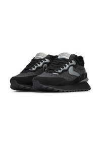 Un paio di scarpe da ginnastica atletiche nero e grigio con lacci e suole testurizzate su uno sfondo bianco.