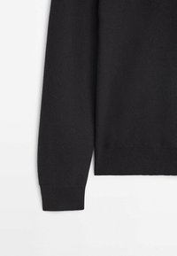 Pull noir à manches longues en maille avec poignets et ourlet côtelés sur fond blanc.