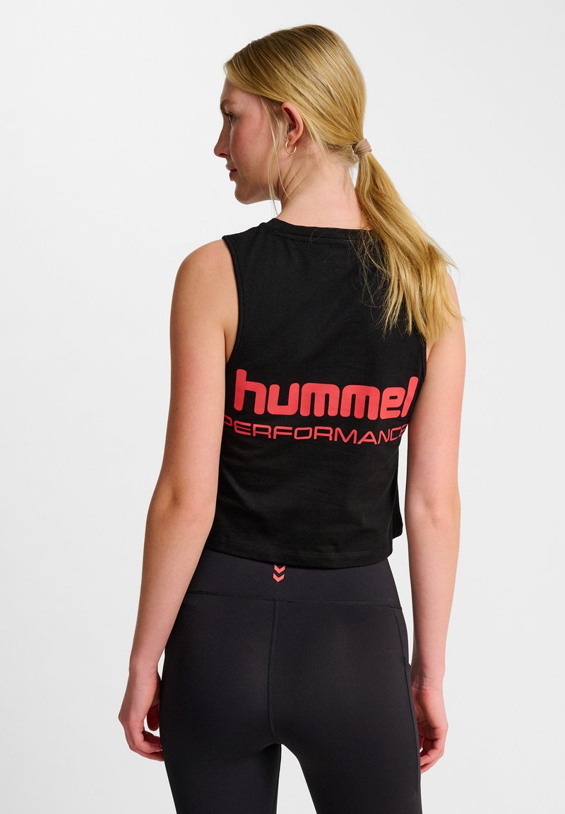 Zwart mouwloos crop top met een opvallend rood "hummel PERFORMANCE" logo op de achterkant. Het materiaal lijkt zacht en lichtgewicht te zijn.