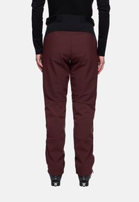 Bordeauxrode skibroek met een hoge taille, zwarte accenten en verstevigde zomen. Gemaakt van een glad, waterbestendig materiaal met een verstelbare tailleband.