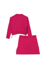 Set di maglione e gonna di colore fucsia. Il maglione ha un colletto rotondo, maniche lunghe e lacci laterali. La gonna presenta dettagli a coste sui lati.