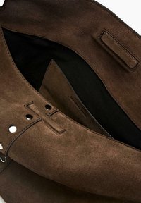 Dunkelbraune Wildledertasche mit schwarzem Stofffutter, magnetischen Druckknöpfen und sichtbaren Nähten auf weißem Hintergrund.