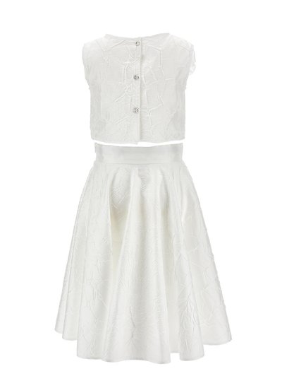 Hvid ærmeløs cropped top med tre knapper kombineret med en høj talje, udvidet midi-nederdel, begge med en subtile rynket tekstur.