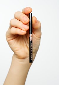 Schwarzer Augenbrauenstift, der in einer Hand gehalten wird. Er hat eine feine Spitze und eine Beschriftung in Pink auf dem Schaft, mit den Aufschriften "Brow Wiz" und "Anastasia Beverly Hills."