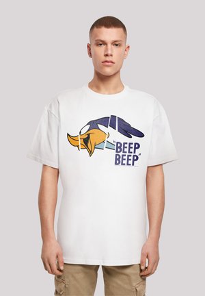 Hvit bomull t-skjorte med et stort grafisk motiv av hodet til en tegneseriefigur med teksten "BEEP BEEP" i blått. Løs passform og korte ermer.