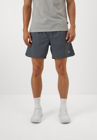 Men's dark gray athletic shorts made from lightweight fabric, featuring an elastic waistband and side pockets, with a small logo accent.