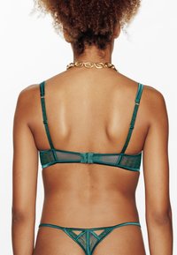 Set di lingerie in pizzo e rete color turchese, con spalline regolabili, schiena trasparente e chiusura ad gancio, abbinato a un perizoma coordinato.