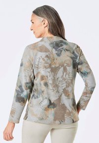 Grijze lange mouw top met een bloemenpatroon in zachte beige, blauwe en bruine tinten, met een ontspannen pasvorm en een gladde textuur.