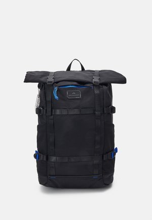Black roll-top backpack with front zipper pocket, adjustable straps, and blue zipper pulls, standing upright on a plain background.