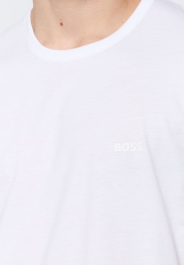 Weißes Baumwoll-T-Shirt mit Rundhalsausschnitt und dezent geprägtem „BOSS“-Logo auf der linken Brust. Weicher Stoff und schlichtes Design.