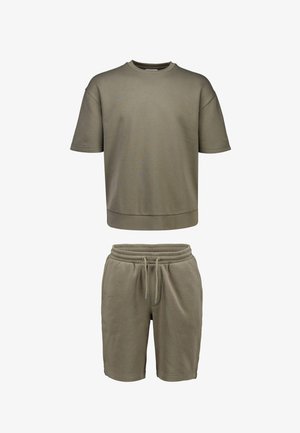 Loszittend olijfgroen T-shirt met korte mouwen en ronde hals met bijpassende short met koord, beide gemaakt van zachte stof voor casual dragen.