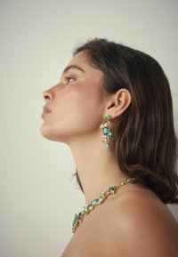 Grüne und gelbe Edelstein-Halskette und passende Ohrringe mit einer goldenen Fassung; filigrane Designs mit verschiedenen Schliffformen und Texturen.