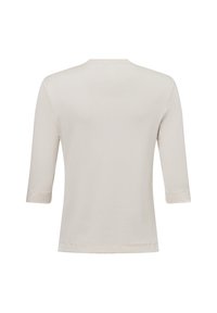 Dreiviertelärmel, hellbeiges Oberteil. Hergestellt aus weichem Stoff mit einem runden Ausschnitt und einem einfachen, nahtlosen Design. Glatte Textur, ohne Muster.
