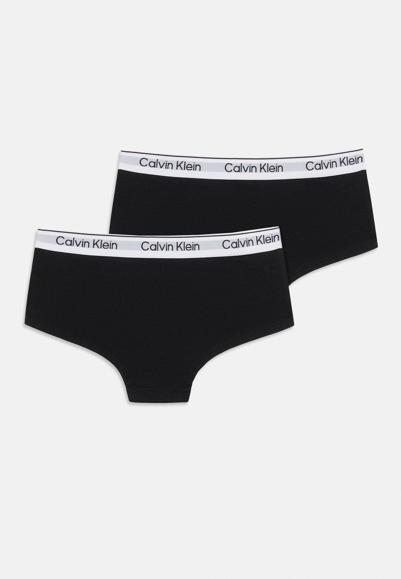Deux caleçons garçon Calvin Klein noirs avec des ceintures élastiques blanches portant le nom de la marque en texte noir.