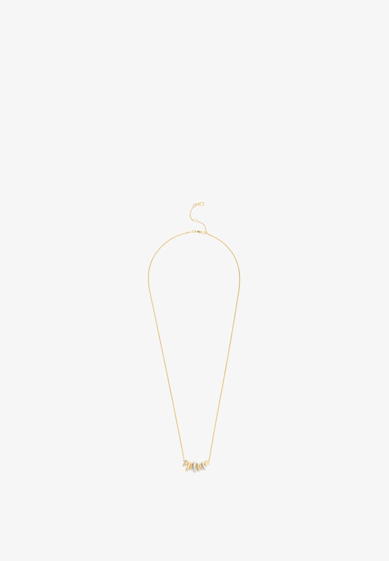 Collier délicat en chaîne d'or avec petits charms en métal mélangé et pierres précieuses répartis de manière uniforme au centre.