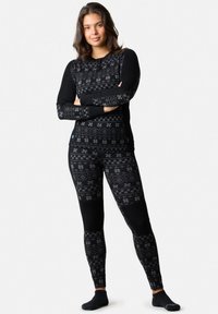 Set termico nero composto da una maglia a maniche lunghe con un motivo e leggings abbinati. Entrambi hanno una consistenza morbida e una forma aderente.