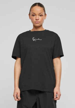 Black short-sleeve t-shirt made of cotton, featuring a white cursive logo on the chest, with a loose fit and a crew neckline.