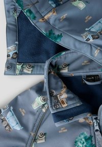 Blaue Jacke mit Comicfahrzeug-Mustern, Fleece-Futter und Reißverschluss. Verfügt über ein kontrastierendes dunkelblaues Innenfutter und ein Textiletikett.