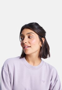 Felpa lavanda chiaro con scollo rotondo e polsini a coste, caratterizzata da un sottile logo a forma di cuore ricamato sul petto.
