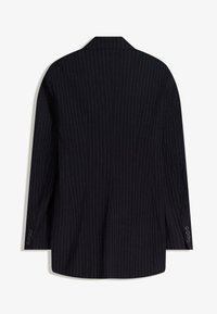 Černý bílý pruhovaný blazer se strukturovaným siluetam, jednopárovým designem, klopovými límci a třemi knoflíkovými detaily na každém rukávu.