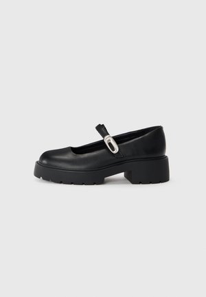 Scarpe Mary Jane nere in pelle con punta rotonda, suola piattaforma spessa e una striscia decorativa con un accento argentato.