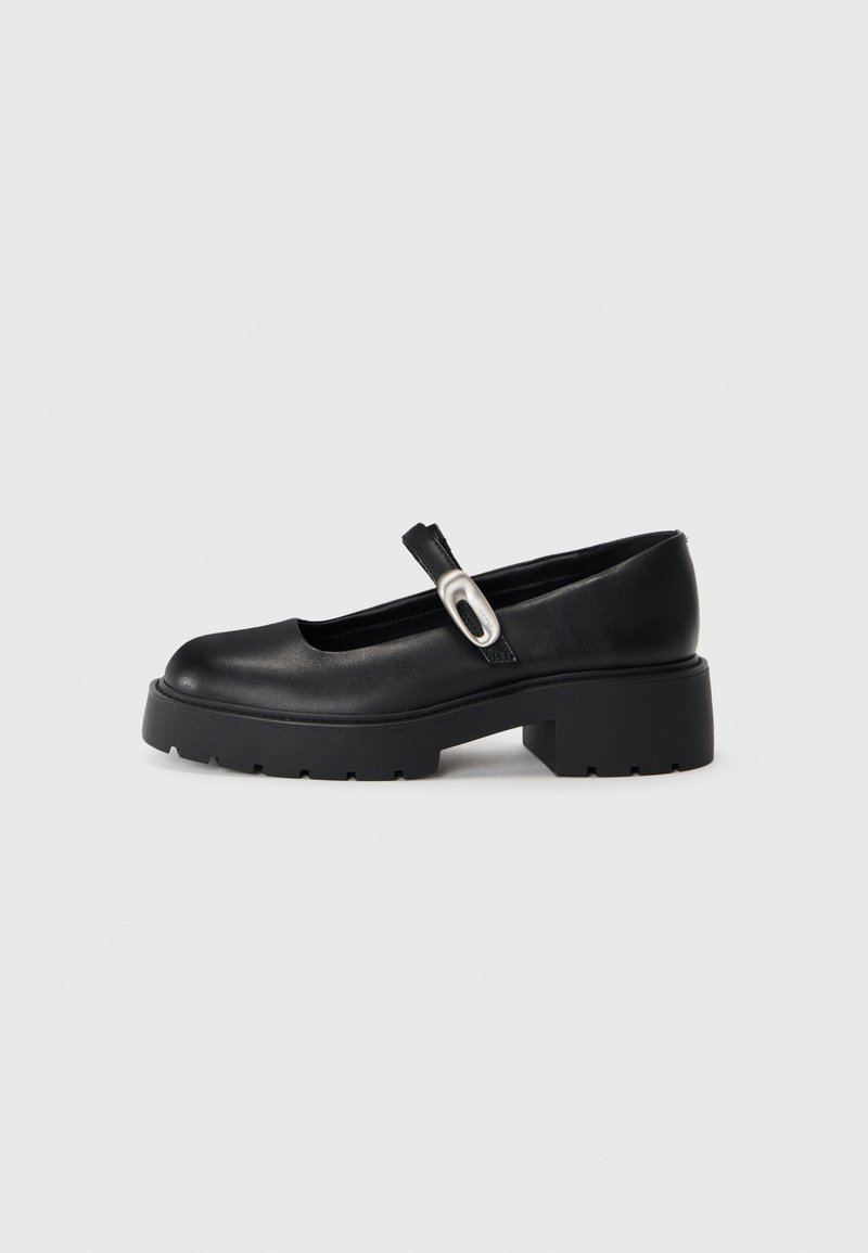 Scarpe Mary Jane nere in pelle con punta rotonda, suola piattaforma spessa e una striscia decorativa con un accento argentato.