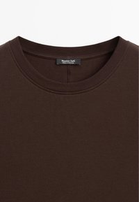 Brun ribbet T-shirt med rund halsudskæring, glat tekstur og mærke med "Massimo Dutti" inden i kraven.