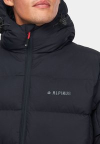 Ciemnoniebieska kurtka puchowa z wysokim kołnierzem, zamkiem błyskawicznym z przodu oraz logo "ALPINUS" na piersi. Gładki, izolowany materiał z regulowanym kapturem.