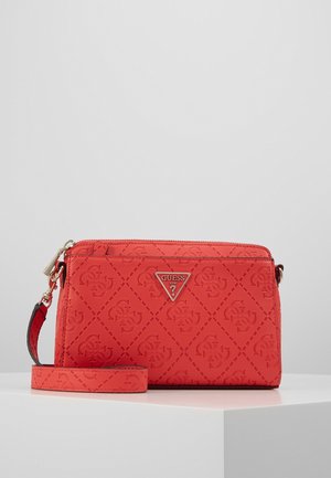 Rode Guess polstasje met reliëf logo patroon, een voorvak met rits en een afneembare band op een wit platform.