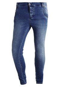 Jeans ajustados de denim en un lavado azul medio. Presentan un cierre frontal con botón, trabillas para cinturón y cinco bolsillos. Textura suave.