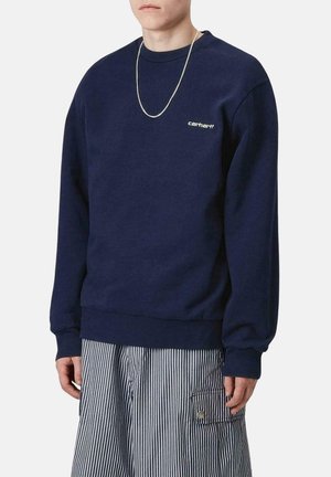 Sudadera azul marino de algodón suave, con cuello redondo, puños y dobladillo acanalados, y un pequeño logo blanco en el pecho.