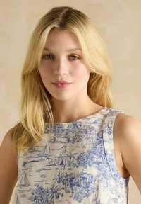 Mėlyna ir balta raštuota be rankovių suknelė, vaizduojanti pakrančių peizažą, pagaminta iš lengvos medžiagos su švelniu tekstūra.