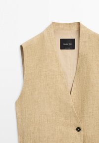 Béžová lněná vesta bez rukávů s jedním černým knoflíkem a černou nášivkou "Massimo Dutti" uvnitř límce.