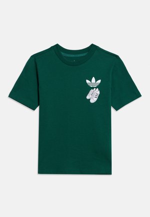 Tmavozelené tričko s krátkym rukávom s malým bielym logom Adidas a grafikou tenisiek na ľavom hrudníku.