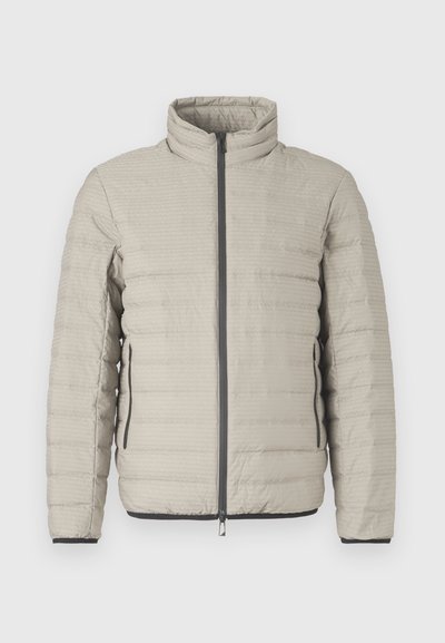 Svetlo siva puhovka z visokim ovratnikom, vodoravnim quiltingom, sprednjo zadrgo in stranskimi žepi. Poudarki v črni barvi na manšetah.