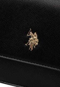 Borsa a mano in pelle nera strutturata con logo dorato del giocatore di polo. Il design è elegante con un motivo sottile e cuciture a contrasto.