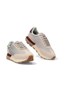 Zapatillas de deporte en gris claro con acentos de ante beige, detalle del talón en color burdeos, suela de goma texturizada y cierre con cordones. Diseño suave y acolchado.