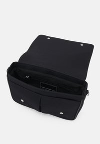 Borsa a spalla in tela nera con chiusura a pattella, due tasche frontali, tasca interna con zip e dettagli in metallo silver.