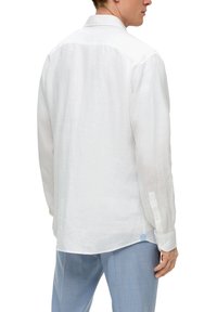 Witte linnen blouse met lange mouwen, knopenmanchetten en een klassieke kraag. Kenmerken zijn een geventileerde zoom en een blauwe accent aan de zijnaad.