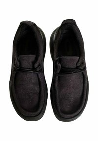 Scarpe slip-on nere realizzate in materiale morbido e strutturato, con punta arrotondata e design minimalista. Presentano lacci elastici per la regolazione della calzata.