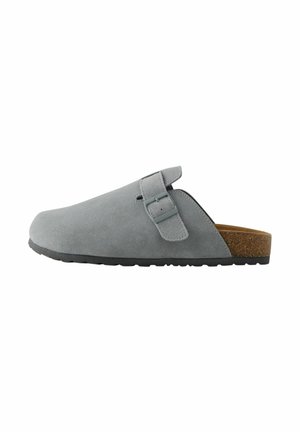 Sivé semišové obuv na slip-on s nastaviteľným pásikom, korkovou stielkou a textúrovanou čiernou gumovou podrážkou. Žiadne viditeľné vzory ani akcenty.