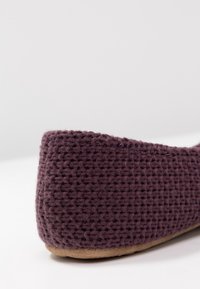 Fioletowe płaskie buty z tkaniny o plecionym wzorze i miękką, beżową podeszwą, z okrągłym noskiem i niskim zapięciem z tyłu.
