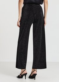 Schwarze, weit geschnittene Hosen aus strukturiertem Stoff mit metallischen Akzenten, ausgestattet mit einem hohen Bund und einem glatten Finish mit leichtem Glanz.