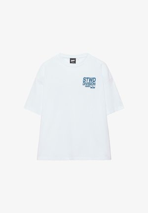 Biała koszulka z krótkim rękawem z niebieskim napisem "STWD DIVISION 1991" i logo na lewej piersi, z okrągłym dekoltem i luźnym krojem.