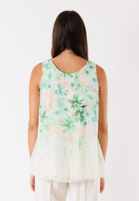 Top leggero senza maniche con stampa floreale nei toni del verde e pesca. Tessuto morbido con scollatura rotonda e vestibilità ampia.