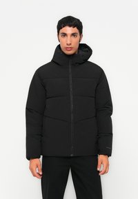 Black puffer jacket with a zip front and adjustable hood. Features a quilted design and elastic cuffs for warmth and comfort.