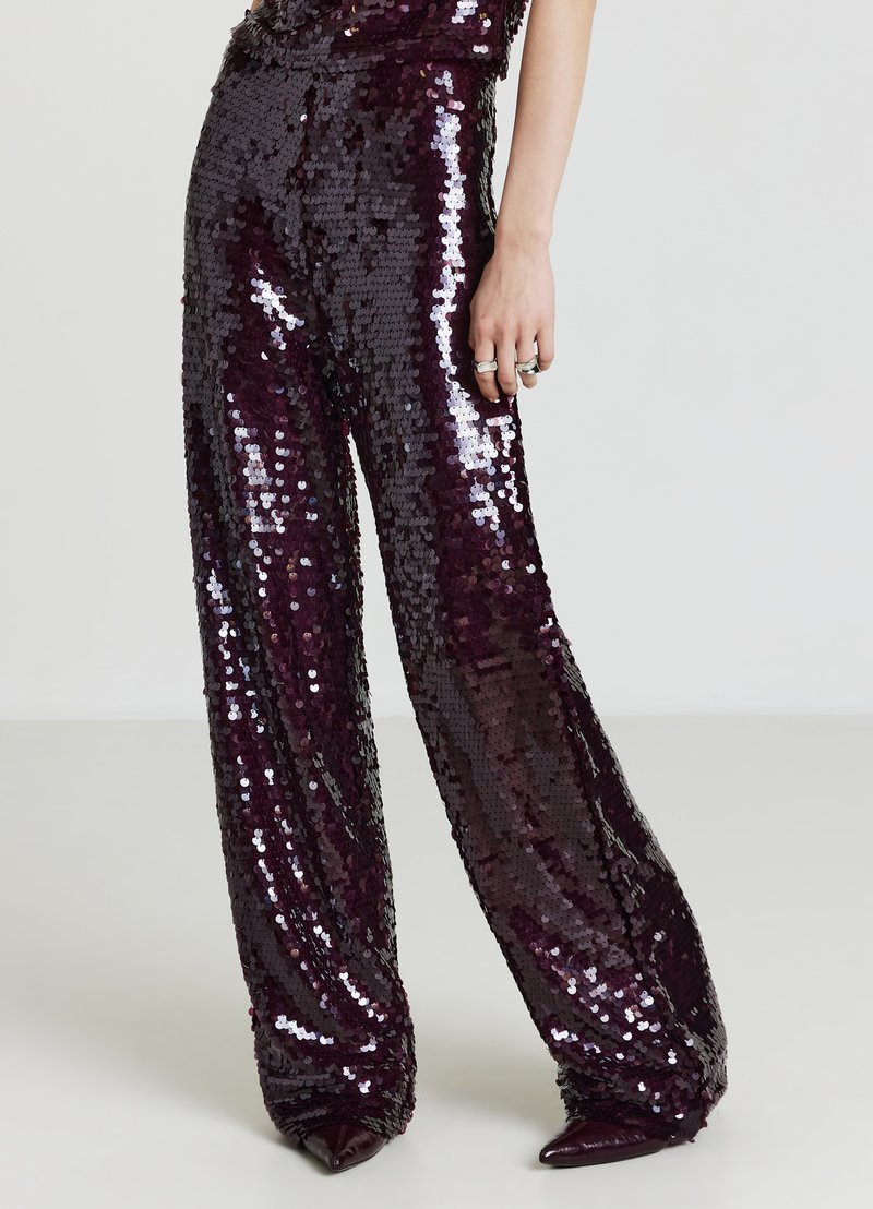 Pantalons larges scintillants en tissu pailleté de couleur bourgogne profond. Présentent une texture brillante et une coupe décontractée.