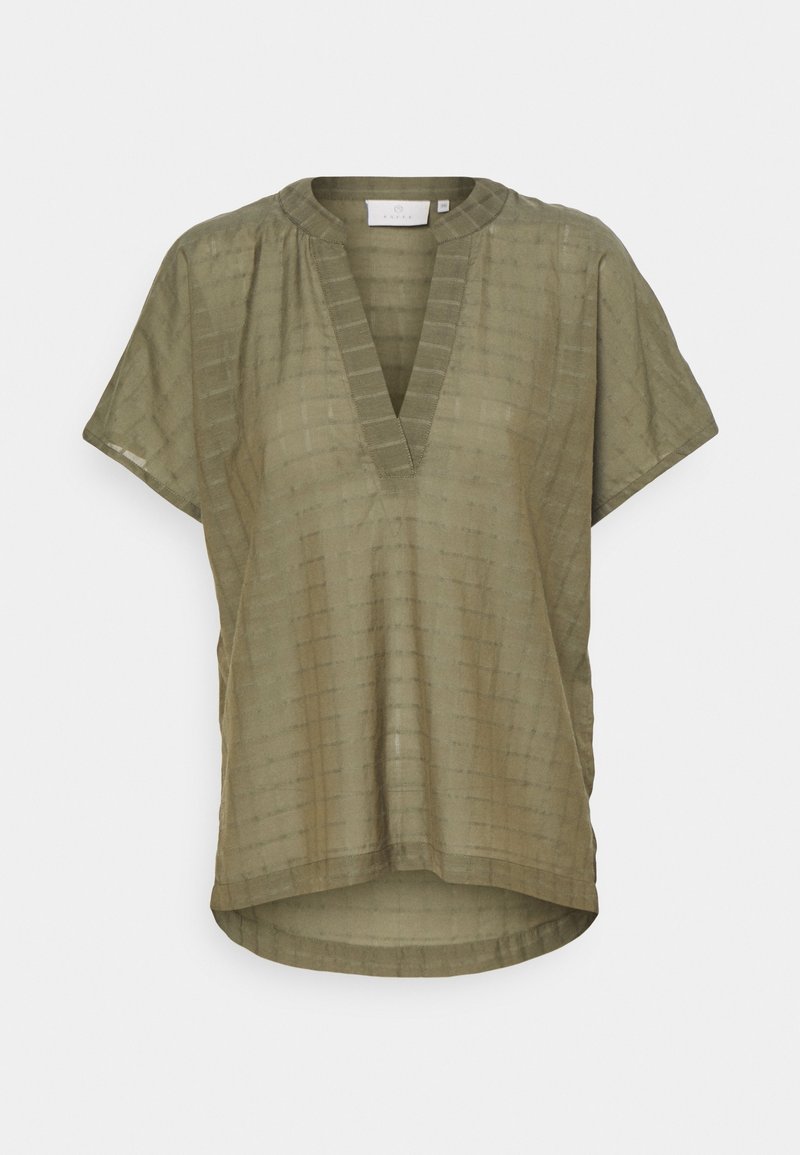 Blouse ample à manches courtes vert olive avec une texture subtile à carreaux, col en V profond, ourlet asymétrique et coupe décontractée.