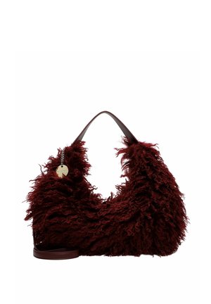 Borsa a mano soffice rosso scuro con pelliccia lunga e strutturata, una singola tracolla e un piccolo ciondolo rotondo dorato attaccato alla tracolla.