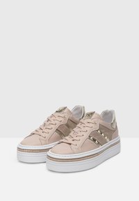 Sneakers in pelle rosa con accenti metallici, strisce laterali testurizzate e suola piatta bianca spessa con cucitura decorativa.